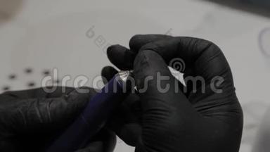 专业的美甲师将一个尖端插入一个特殊的指甲油去除剂。